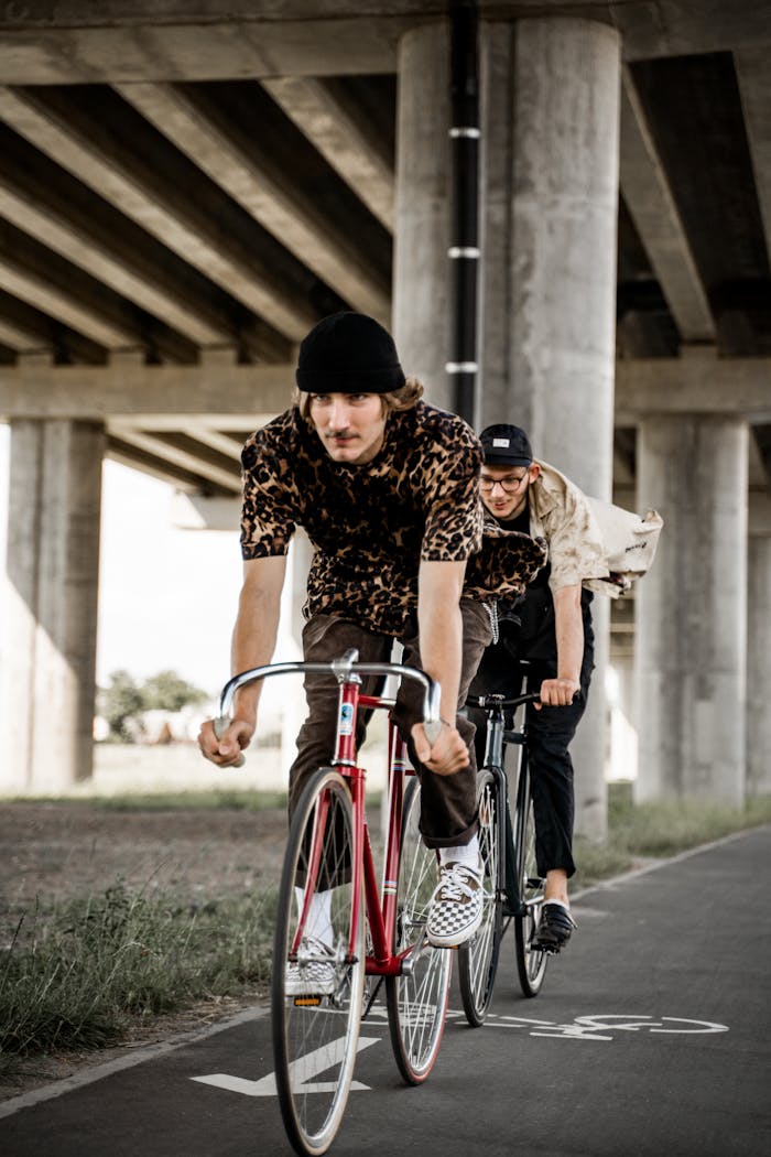 pexels-photo-5061169 Two men cycling under an urban overpass, showcasing adventure and fitness.
